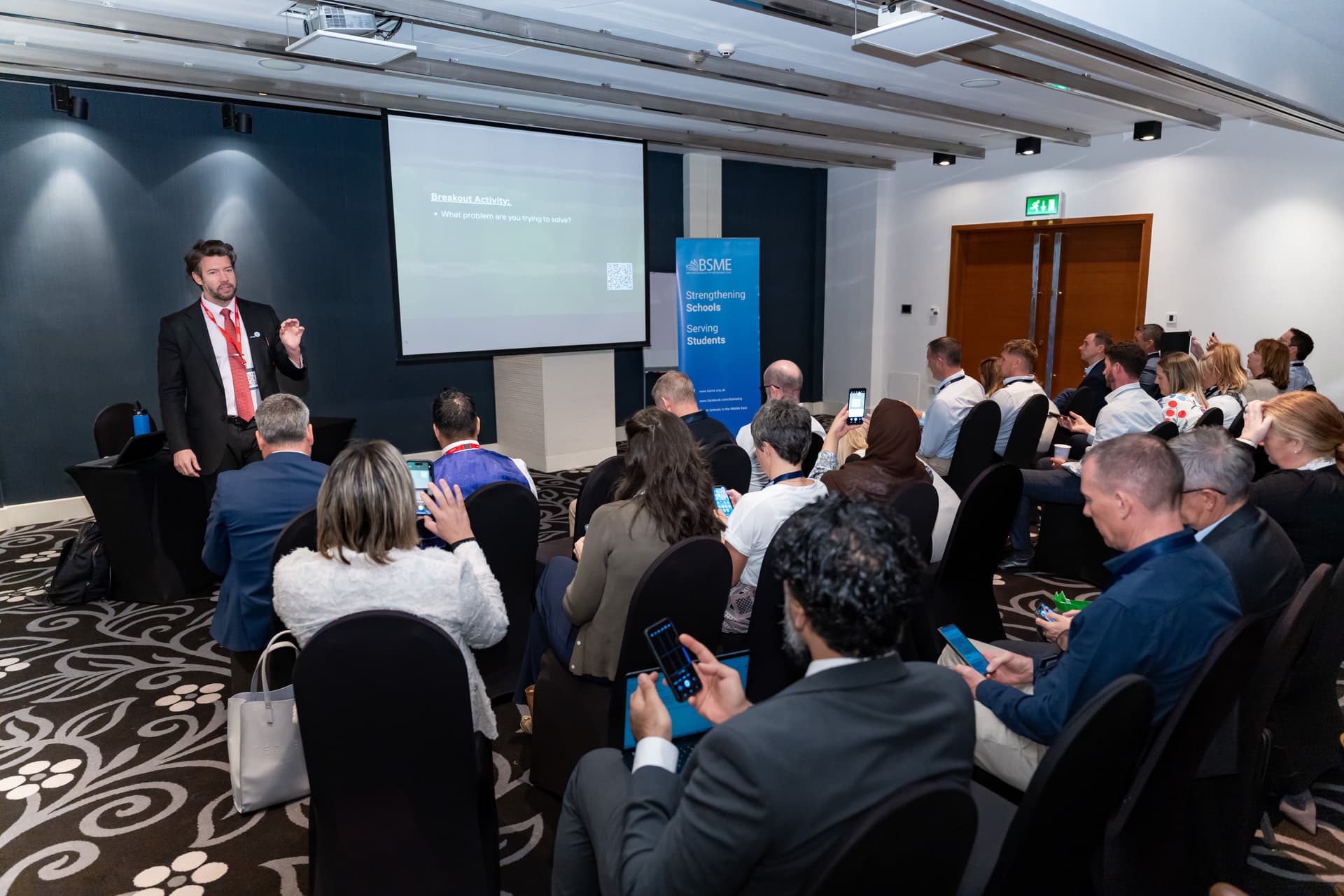 Alex presenting to a packed conference room at BSME